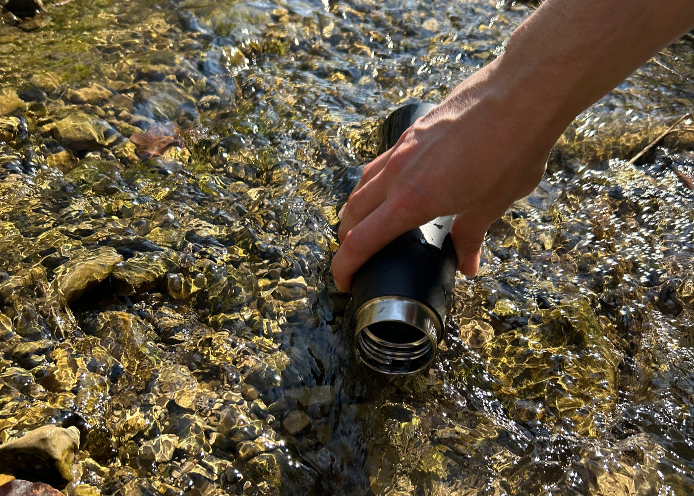 Wasser aus Bach trinken